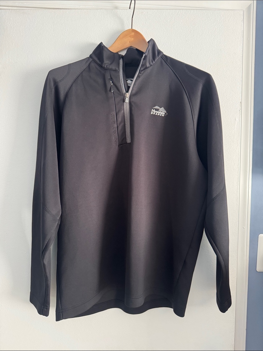 Sun Mountain golf black 1/4 zip. Thermal Flex gear. Mountain Branch emblem.